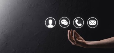 İş adamı el ele tutuşması, ikon telefona, postaya, telefona, telefona, mesaja, iletiye ve kişiye, kullanıcıya basmak. Müşteri hizmetleri çağrı merkezi bizimle konsept bağlantı kurar. Banner, kopyalama alanı. İletişim Yöntemleri