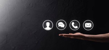 İş adamı el ele tutuşması, ikon telefona, postaya, telefona, telefona, mesaja, iletiye ve kişiye, kullanıcıya basmak. Müşteri hizmetleri çağrı merkezi bizimle konsept bağlantı kurar. Banner, kopyalama alanı. İletişim Yöntemleri