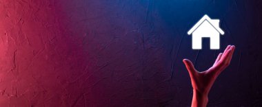 Emlak konsepti, iş adamı ev ikonu tutuyor. Ev elden gidiyor. Emlak sigortası ve güvenlik kavramı. İnsanın jestini ve evin sembolünü koruyorum..