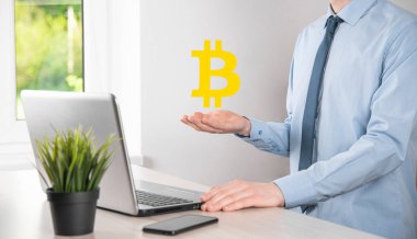 Mavi arka planda Bitcoin ikonu tutan bir erkek el. Bitcoin Şifreleme Dijital Bit Parası BTC Para Birimi Teknolojisi İnternet Konsepti