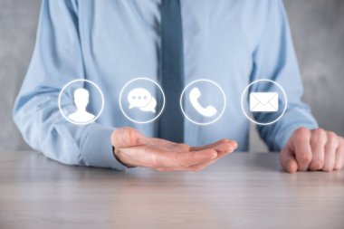 İş adamı el ele tutuşması, ikon telefona, postaya, telefona, telefona, mesaja, iletiye ve kişiye, kullanıcıya basmak. Müşteri hizmetleri çağrı merkezi bizimle konsept bağlantı kurar. Banner, kopyalama alanı. İletişim Yöntemleri