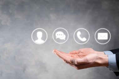 İş adamı el ele tutuşması, ikon telefona, postaya, telefona, telefona, mesaja, iletiye ve kişiye, kullanıcıya basmak. Müşteri hizmetleri çağrı merkezi bizimle konsept bağlantı kurar. Banner, kopyalama alanı. İletişim Yöntemleri