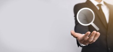 Erkek el büyüteç tutuyor, mavi arkaplanda arama simgesi var. Konsept arama motoru optimizasyonu, müşteri desteği. İnternet Veri Bilgilerine göz atılıyor. Ağ Konsepti