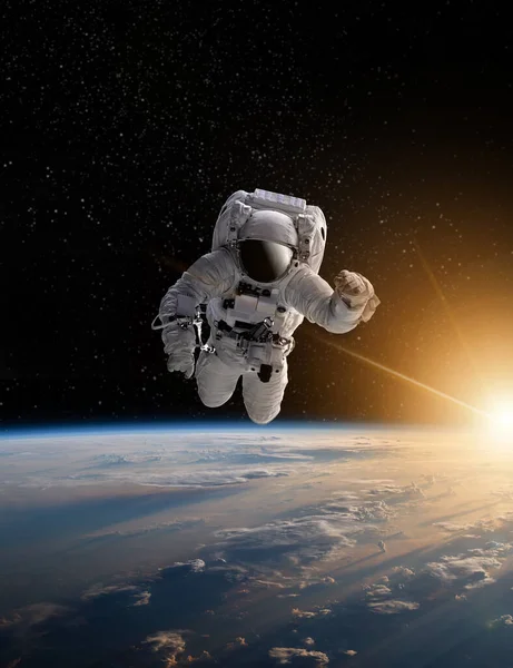 Astronaut in outer space over the planet Earth.Stars provide the background.erforming a space above planet Earth.Sunrise,sunset.Our home. ISS.Elements of this Image Furnished by NASA