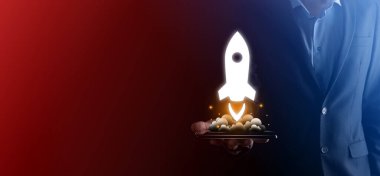 Girişim konsepti, Tablet ve simge roketi tutan İşadamı ekrandan koyu arkaplanda ağ bağlantısı ile fırlıyor ve yükseliyor