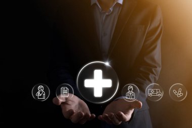 İş adamının elinde sanal ve tıbbi ağ bağlantısı simgeleri var. Covid-19 salgını insanları bilinçlendirir ve sağlık hizmetlerine dikkat çeker. Doktor, belge, ilaç, ambulans, hasta ikonu