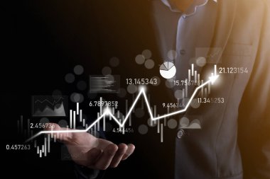 Eldeki iş adamı bankacılık işletme finans grafiği ve borsa yatırım noktası, ekonomik büyüme ve yatırımcı konseptine yatırım yapıyor. Analiz sanal borsa grafiği, teknoloji kullanarak analiz edilir.