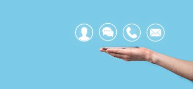 İş adamı el ele tutuşması, ikon telefona, postaya, telefona, telefona, mesaja, iletiye ve kişiye, kullanıcıya basmak. Müşteri hizmetleri çağrı merkezi bizimle konsept bağlantı kurar. Banner, kopyalama alanı. İletişim Yöntemleri