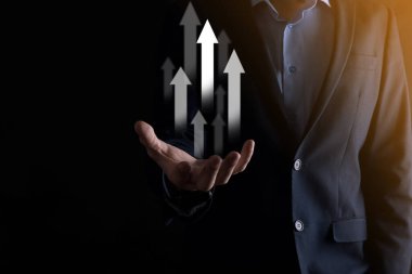 Holografik grafikler ve borsa istatistikleri tutan işadamı kâr elde ediyor. Büyüme planlama ve iş stratejisi kavramı. İyi ekonomi formunun dijital ekran görüntüsü.