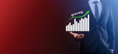 Holografik grafikler ve borsa istatistikleri tutan işadamı kâr elde ediyor. Büyüme planlama ve iş stratejisi kavramı. İyi ekonomi formunun dijital ekran görüntüsü.