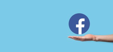 Onok, Ukrayna - 14 Temmuz 2021: İş adamı elinde, tıklama, Facebook simgesi tutuyor. Sosyal ağ. Küresel ağ ve veri müşteri bağlantısı. Uluslararası ağ
