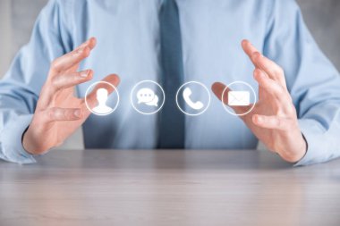 İş adamı el ele tutuşması, ikon telefona, postaya, telefona, telefona, mesaja, iletiye ve kişiye, kullanıcıya basmak. Müşteri hizmetleri çağrı merkezi bizimle konsept bağlantı kurar. Banner, kopyalama alanı. İletişim Yöntemleri
