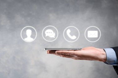 İş adamı el ele tutuşması, ikon telefona, postaya, telefona, telefona, mesaja, iletiye ve kişiye, kullanıcıya basmak. Müşteri hizmetleri çağrı merkezi bizimle konsept bağlantı kurar. Banner, kopyalama alanı. İletişim Yöntemleri