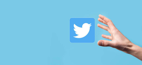 Onok,Ukraine - July 14,2021:Businessman holds, clicks, TWITTER icon in his hands.Social network.global network and data customer connection.international network