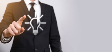 Ampulü tut. Elinde parlak bir fikir simgesi tutuyor. İş fikri kavramı. Yenilik, beyin fırtınası, ilham ve çözüm kavramları..