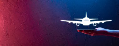 Erkek el, mavi arka planda uçak ikonunu tutuyor. Banner. Nline bilet alımı. Seyahat planlama, ulaşım, otel, uçuş ve pasaport ikonları.