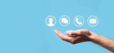 İş adamı el ele tutuşması, ikon telefona, postaya, telefona, telefona, mesaja, iletiye ve kişiye, kullanıcıya basmak. Müşteri hizmetleri çağrı merkezi bizimle konsept bağlantı kurar. Banner, kopyalama alanı. İletişim Yöntemleri