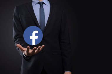 Onok, Ukrayna - 14 Temmuz 2021: İş adamı elinde, tıklama, Facebook simgesi tutuyor. Sosyal ağ. Küresel ağ ve veri müşteri bağlantısı. Uluslararası ağ