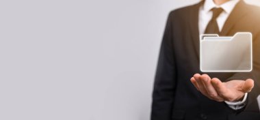 İş adamı dizin simgesini tutuyor. Belge Yönetim Sistemi veya modern bilgisayar bilişim danışmanı tarafından kurulmuş DMS yönetici dosyaları ve kurumsal dosyaları arıyor. İş işleme