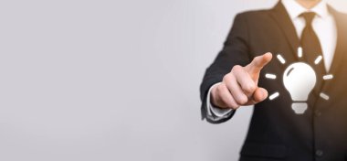 Elinde ampul olan takım elbiseli bir iş adamı. Elinde parlak bir fikir simgesi tutuyor. Metin için bir yer ile.