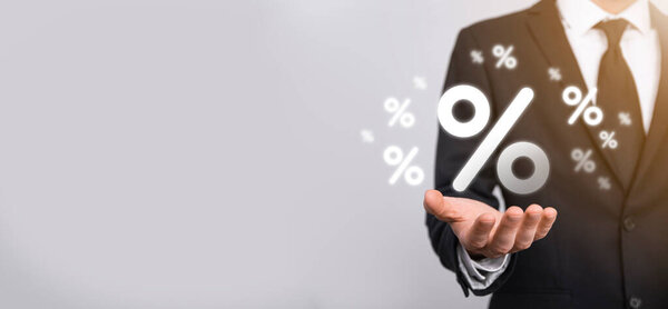 Мужчина держит значок процентной ставки на синем фоне. Процентная ставка Финансовые и ипотечные ставки Concept.Banner с копировальным пространством.