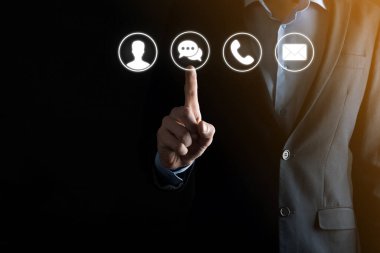 İş adamı el ele tutuşması, ikon telefona, postaya, telefona, telefona, mesaja, iletiye ve kişiye, kullanıcıya basmak. Müşteri hizmetleri çağrı merkezi bizimle konsept bağlantı kurar. Banner, kopyalama alanı. İletişim Yöntemleri