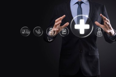 İş adamının elinde sanal ve tıbbi ağ bağlantısı simgeleri var. Covid-19 salgını insanları bilinçlendirir ve sağlık hizmetlerine dikkat çeker. Doktor, belge, ilaç, ambulans, hasta ikonu