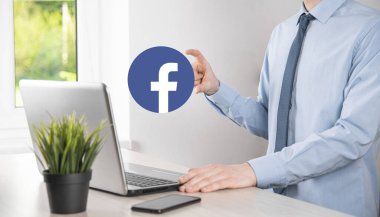 Onok, Ukrayna - 14 Temmuz 2021: İş adamı elinde, tıklama, Facebook simgesi tutuyor. Sosyal ağ. Küresel ağ ve veri müşteri bağlantısı. Uluslararası ağ