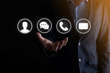 İş adamı el ele tutuşması, ikon telefona, postaya, telefona, telefona, mesaja, iletiye ve kişiye, kullanıcıya basmak. Müşteri hizmetleri çağrı merkezi bizimle konsept bağlantı kurar. Banner, kopyalama alanı. İletişim Yöntemleri