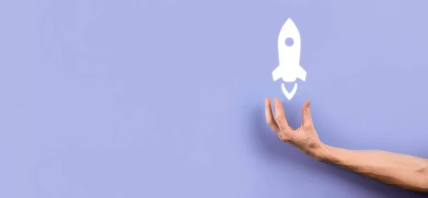 stock image Male hand holding rocket icon that takes off, launch on blue background. rocket is launching and flying out, Business start up, Icon marketing on modern virtual interface.Start up concept