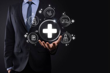 İş adamının elinde sanal ve tıbbi ağ bağlantısı simgeleri var. Covid-19 salgını insanları bilinçlendirir ve sağlık hizmetlerine dikkat çeker. Doktor, belge, ilaç, ambulans, hasta ikonu