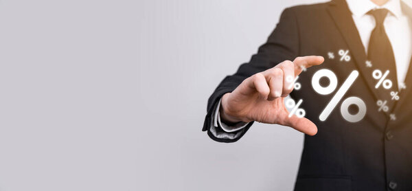 Мужчина держит значок процентной ставки на синем фоне. Процентная ставка Финансовые и ипотечные ставки Concept.Banner с копировальным пространством.