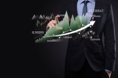 İş adamı satış verilerini ve ekonomik büyüme grafiğini elinde tutuyor. İş planlama ve strateji. Takas ticareti analiz ediliyor. Finansal ve bankacılık. Teknoloji dijital pazarlama. Kâr ve büyüyen plan.