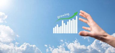 Holografik grafikler ve borsa istatistikleri tutan işadamı kâr elde ediyor. Büyüme planlama ve iş stratejisi kavramı. İyi ekonomi formunun dijital ekran görüntüsü.