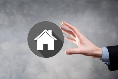 Emlak konsepti, iş adamı ev ikonu tutuyor. Ev elden gidiyor. Emlak sigortası ve güvenlik kavramı. İnsanın jesti ve ev sembolü. Uzun gölgeli düz ikonlar..