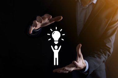 İş adamı elinde ampullü bir ikon tutuyor, yenilikçi teknoloji ve yaratıcılıkla yeni fikirler üretiyor. Işıldayan ampullerle yaratıcılık kavramı