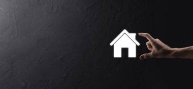 Emlak konsepti, iş adamı ev ikonu tutuyor. Ev elden gidiyor. Emlak sigortası ve güvenlik kavramı. İnsanın jestini ve evin sembolünü koruyorum..