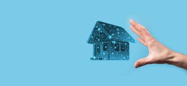 Adam düşük poligonlu. Emlak konsepti, iş adamı ev ikonu tutuyor. Ev elden gidiyor. Emlak sigortası ve güvenlik kavramı. İnsanın jestini ve evin sembolünü koruyorum..