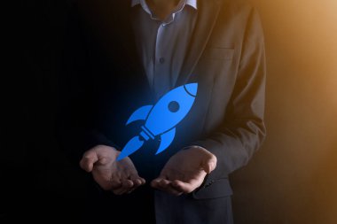 Soyut dijital roket ikonu taşıyan iş adamı konsepti fırlatılıyor ve yükseliyor.