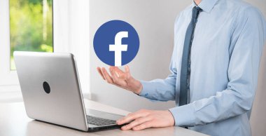Onok, Ukrayna - 14 Temmuz 2021: İş adamı elinde, tıklama, Facebook simgesi tutuyor. Sosyal ağ. Küresel ağ ve veri müşteri bağlantısı. Uluslararası ağ