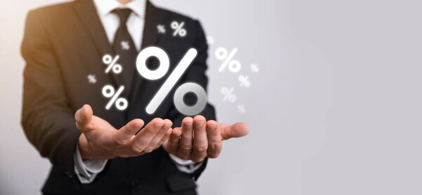 Мужчина держит значок процентной ставки на синем фоне. Процентная ставка Финансовые и ипотечные ставки Concept.Banner с копировальным пространством.