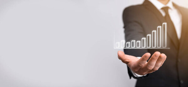 Бизнесмен держит график роста и увеличения диаграммы положительных показателей в своем бизнесе. Инвестиции до концепции. Анализ данных продаж и экономических, стратегии и планирования, цифровой маркетинг и фондовый рынок.