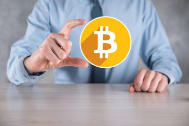 Erkek el gri arka planda bir bitcoin simgesi tutuyor. Bitcoin Şifreleme Dijital Bit Parası BTC Para Birimi Teknolojisi İnternet Konsepti.
