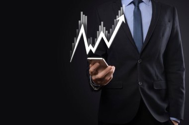 İş adamı satış verilerini ve ekonomik büyüme grafiğini elinde tutuyor. İş planlama ve strateji. Takas ticareti analiz ediliyor. Finansal ve bankacılık. Teknoloji dijital pazarlama. Kâr ve büyüyen plan.