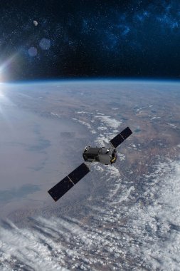 Kargo uzay aracı Dünya gezegeni. Karanlık arka plan. Bilim kurgu duvar kağıdı. Uzay İstasyonu Dünya 'nın yörüngesindeki uzay gemisi. Uzay sanat duvar kağıdı. Güneş Gözlemevi. Bu görüntünün unsurları NASA3D illüstrasyon tarafından desteklenmektedir..