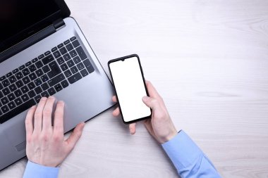 İşyerleri ahşap ofis masaları boş cep telefonları, çeşitli malzemeler. Model yap. Laptop, akıllı telefon, bir fincan kahve.