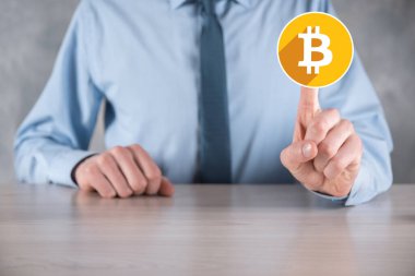 Erkek el gri arka planda bir bitcoin simgesi tutuyor. Bitcoin Şifreleme Dijital Bit Parası BTC Para Birimi Teknolojisi İnternet Konsepti.