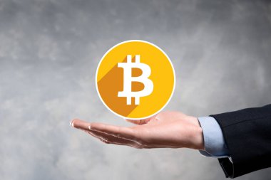 Erkek el gri arka planda bir bitcoin simgesi tutuyor. Bitcoin Şifreleme Dijital Bit Parası BTC Para Birimi Teknolojisi İnternet Konsepti.