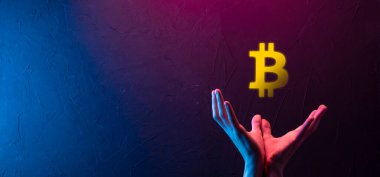 Mavi arka planda Bitcoin ikonu tutan bir erkek el. Bitcoin Şifreleme Dijital Bit Parası BTC Para Birimi Teknolojisi İnternet Konsepti