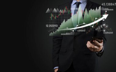 İş adamı satış verilerini ve ekonomik büyüme grafiğini elinde tutuyor. İş planlama ve strateji. Takas ticareti analiz ediliyor. Finansal ve bankacılık. Teknoloji dijital pazarlama. Kâr ve büyüyen plan.